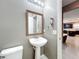 Small bathroom with pedestal sink and view into the kitchen at 5036 Gandross Ln, Mount Dora, FL 32757