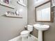 Charming small bathroom with pedestal sink and decorative shelving at 5036 Gandross Ln, Mount Dora, FL 32757