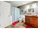 Bathroom with wooden vanity and floral shower curtain at 5036 Gandross Ln, Mount Dora, FL 32757