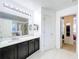 Elegant bathroom with dark vanity, white tile floor, and a large mirror at 5036 Gandross Ln, Mount Dora, FL 32757