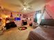 Pink bedroom with bed, TV, and eclectic decor at 5036 Gandross Ln, Mount Dora, FL 32757