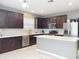 Modern kitchen with island, stainless steel appliances, and dark wood cabinets at 5036 Gandross Ln, Mount Dora, FL 32757