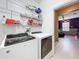 Bright laundry room with washer, dryer, and shelving; view of office at 5036 Gandross Ln, Mount Dora, FL 32757