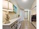 Bright hallway with tile flooring, white cabinet, and a view to a home office at 5046 Harbour Dr, Oxford, FL 34484