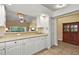 Open concept kitchen with white cabinets, granite countertops, and pass-through to the living room at 5046 Harbour Dr, Oxford, FL 34484