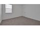 Bright bedroom featuring plush carpet, large window and a door leading to the rest of the house at 5095 Firebush Dr, Apopka, FL 32712