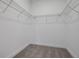 Spacious walk-in closet features neutral carpet and multiple shelves for ample storage at 5095 Firebush Dr, Apopka, FL 32712