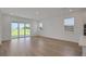 Light filled living area with wood floors, large windows and a sliding glass door to the backyard at 5095 Firebush Dr, Apopka, FL 32712