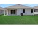 Home featuring a cozy, covered patio area and a well-manicured lawn, perfect for outdoor enjoyment at 5131 Firebush Dr, Apopka, FL 32712