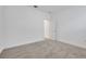 A bright, carpeted bedroom features white walls and an open doorway, offering a glimpse into another room at 5131 Firebush Dr, Apopka, FL 32712