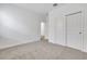 Spacious bedroom featuring neutral carpet, white walls, an open door, and a sliding-door closet at 5131 Firebush Dr, Apopka, FL 32712