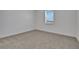 Bright bedroom featuring neutral carpet, white walls, and natural light from one window with blinds at 5131 Firebush Dr, Apopka, FL 32712