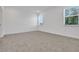 Bright bedroom featuring neutral carpet, white walls, and natural light from two large windows at 5131 Firebush Dr, Apopka, FL 32712