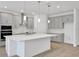Open kitchen features gray cabinets, a center island, and stainless steel appliances at 5131 Firebush Dr, Apopka, FL 32712
