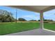 Covered patio showcasing a picturesque view of an expansive green field and clear blue sky at 5131 Firebush Dr, Apopka, FL 32712