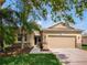 Tan house with a two-car garage and landscaped lawn at 5929 Coquyt, Mount Dora, FL 32757