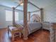 Main bedroom with a four-poster bed and hardwood floors at 5929 Coquyt Dr, Mount Dora, FL 32757