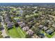 Aerial view of a residential neighborhood with lush landscaping and lake access at 6220 Topsail Rd, Lady Lake, FL 32159