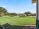 Landscaped backyard with grassy area and neighborhood view at 6220 Topsail Rd, Lady Lake, FL 32159