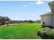 Landscaped backyard with a view of the neighborhood and golf course at 6220 Topsail Rd, Lady Lake, FL 32159