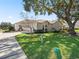 One-story house with attached garage and lush lawn at 6220 Topsail Rd, Lady Lake, FL 32159