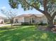 House exterior showcasing a large tree and manicured lawn at 6220 Topsail Rd, Lady Lake, FL 32159