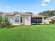 House exterior with a spacious lawn and screened patio at 6220 Topsail Rd, Lady Lake, FL 32159