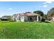 House exterior showcasing a large backyard and screened porch at 6220 Topsail Rd, Lady Lake, FL 32159