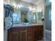 Double vanity bathroom with wood cabinets and a large mirror at 670 Murphys Estate Dr, The Villages, FL 32162