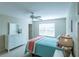 Bedroom with ceiling fan, dresser, and teal bedding at 670 Murphys Estate Dr, The Villages, FL 32162