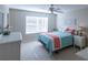 Cozy bedroom with a ceiling fan and light teal bedding at 670 Murphys Estate Dr, The Villages, FL 32162