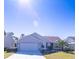 Tan house with a two-car garage and palm trees at 670 Murphys Estate Dr, The Villages, FL 32162