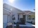 Front view of tan house with walkway and landscaping at 670 Murphys Estate Dr, The Villages, FL 32162