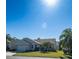 One-story house with a bright lawn and palm trees under a sunny sky at 670 Murphys Estate Dr, The Villages, FL 32162