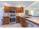 Modern kitchen with stainless steel appliances and wood cabinets at 670 Murphys Estate Dr, The Villages, FL 32162