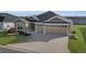 House exterior with two-car garage and landscaped front yard at 6851 Wendy Way, The Villages, FL 34762