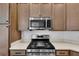 Modern kitchen features stainless steel appliances and light wood cabinets at 6851 Wendy Way, The Villages, FL 34762