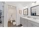 Modern bathroom with double vanity, gray cabinets, and a separate toilet area at 7189 Denver Ave, The Villages, FL 34762