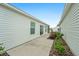 Side yard with concrete patio and landscaping at 7189 Denver Ave, The Villages, FL 34762