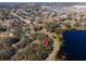 Aerial view showing land plot by lake and houses at 73 N Carol Ave, Mascotte, FL 34753