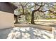 Concrete patio area adjacent to the house, surrounded by trees and landscaping at 73 N Carol Ave, Mascotte, FL 34753