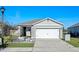 Single-story house with gray exterior, white double garage doors, and well-maintained landscaping at 808 Brooklet Dr, Davenport, FL 33837