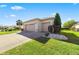 Two-car garage with a side door and neatly landscaped surroundings at 9565 Se 124Th Loop, Summerfield, FL 34491