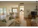Bright living room featuring wood floors, neutral furnishings, and an open floor plan to the kitchen and dining areas at 9565 Se 124Th Loop, Summerfield, FL 34491