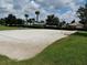 Outdoor sand volleyball court with blue net and lines, surrounded by trees and grass, ideal for recreational play at 9565 Se 124Th Loop, Summerfield, FL 34491