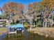 Aerial view of waterfront home with dock and lush trees at 9724 Rosemary Ln, Leesburg, FL 34788