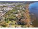 Aerial view of a home on the water with a large yard and dock at 9724 Rosemary Ln, Leesburg, FL 34788