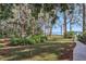 Landscaped backyard with a lake view and a walkway at 9724 Rosemary Ln, Leesburg, FL 34788