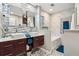 Modern bathroom with double sinks, a soaking tub, and marble tile at 9724 Rosemary Ln, Leesburg, FL 34788