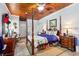 Main bedroom with post bed, ceiling fan and hardwood floor at 9724 Rosemary Ln, Leesburg, FL 34788